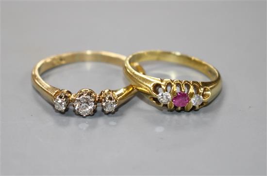 A modern 18ct gold, ruby and diamond set three stone ring and an 18ct and three stone diamond ring,